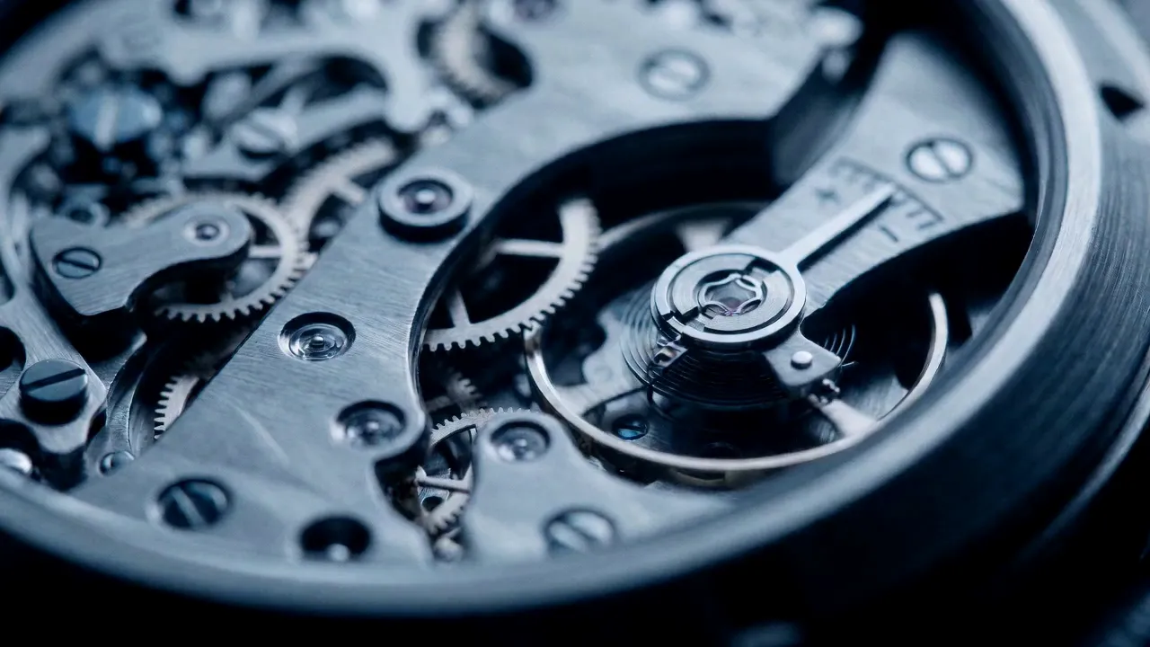 Macro view of a mechanical watch movement: gears, jewelled bearings and the balance wheel in cool steel light.
